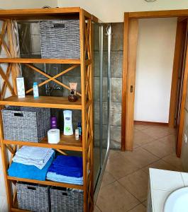 a bathroom with a shower and a shelf with towels at Yuna&Stella in Oristano