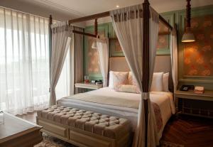 a bedroom with a canopy bed and a window at The Evren, Vagator in Vagator