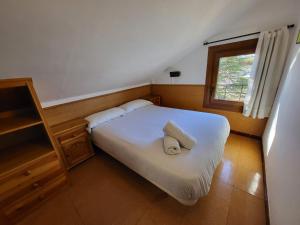 a bedroom with a bed with two pillows and a window at Apto De Montaña En Puigcerdà in Puigcerdà