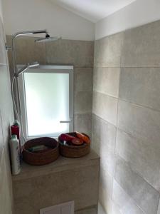 a bathroom with two baskets on a shelf with a mirror at Appartement 2 ch Anglet Biarritz in Anglet