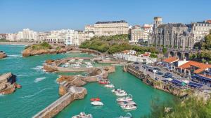 a group of boats in a river in a city at Appartement 2 ch Anglet Biarritz in Anglet +4 photos
