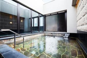 a swimming pool in a building with windows at Hotel Sonia Otaru in Otaru