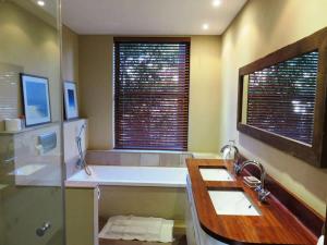 a bathroom with a tub and a sink and a mirror at Table Mountain Villa in Cape Town