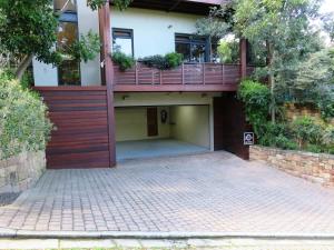 a house with a balcony and a brick driveway at Table Mountain Villa in Cape Town