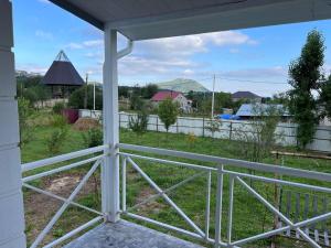 a porch with a view of a field and a fence at Shamaxı Villa in Şamaxı