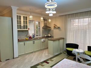 a kitchen with green cabinets and a table and chairs at Shamaxı Villa in Şamaxı