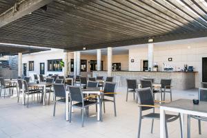 Un restaurante con mesas y sillas y un bar. en Bakour La Manga Splash, en La Manga del Mar Menor