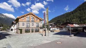 a large building with a flag in front of it at FRANZ alpine living - Apartments in Sankt Anton am Arlberg