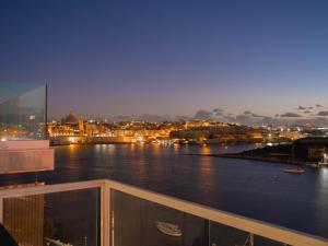 a view of a river at night from a balcony at Tigné Seafront Apartments & Penthouse with Heated Jacuzzi in Sliema