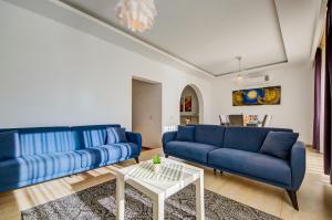 a living room with blue couches and a table at Tigné Seafront Apartments & Penthouse with Heated Jacuzzi in Sliema +71 photos