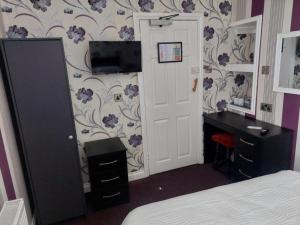 a bedroom with a bed and a desk and a door at Edenfield Lodge in Blackpool