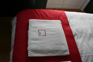 a white towel on a white blanket on a bed at 2U Oporto Urban Stays in Porto