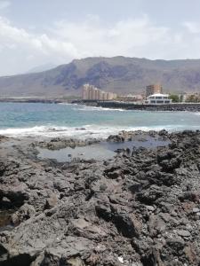 plaża z kamieniami, ocean i budynki w obiekcie Casa ecologica, autosuficiente en Lomo Blanco, dentro de una casa rodeada de naturaleza w mieście San Juan de la Rambla +37 zdjęć