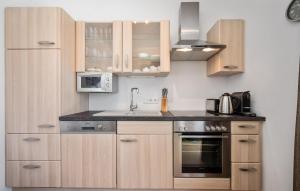 Una cocina con gabinetes de madera y un fregadero. en Ferienwohnung 41M² Top1, en Pörtschach am Wörthersee