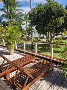 a wooden bench sitting on top of a wooden deck at Pousada Vila da Barra in Ilha de Boipeba