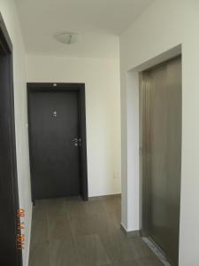 a hallway with a black door in a room at ApartComplex New Tоwn in Obzor
