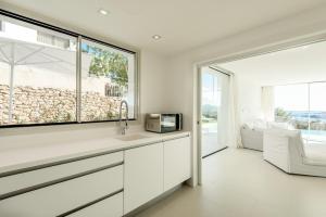 eine weiße Küche mit Spüle und Mikrowelle in der Unterkunft Charming Ibiza Villa with 4 Bedrooms, 1265 in Talamanca