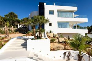 ein weißes Haus mit Palmen davor in der Unterkunft Charming Ibiza Villa with 4 Bedrooms, 1265 in Talamanca