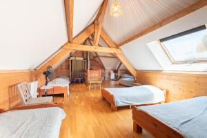 a attic room with three beds and a window at La Buena Onda in Herrère