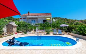 a swimming pool in front of a house at Beautiful Home In Sibenik in Šibenik +25 photos