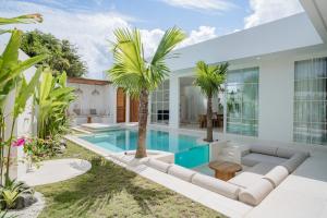 a villa with a swimming pool and palm trees at Nisí Villas Bingin, Uluwatu in Uluwatu