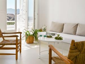 a living room with a couch and a table at Mykonos Lolita, a Resort to Live in Agios Sostis Mykonos