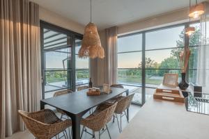 a dining room with a table and chairs and a large window at Casa San Verde Hill in Novaki Motovunski