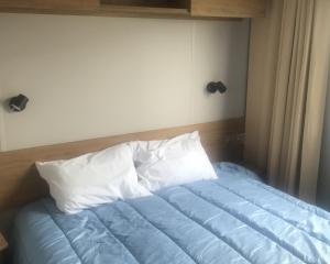 a bed with blue sheets and white pillows at Le Domaine de Litteau 4 étoiles à LITTEAU emplacement 443 3CH 1SDB 6 personnes in Litteau