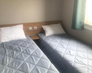 a bedroom with two beds and a window at Le Domaine de Litteau 4 étoiles à LITTEAU emplacement 443 3CH 1SDB 6 personnes in Litteau