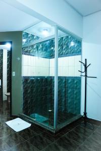 a bathroom with a glass shower with a cross on the floor at Rodotel Vênus Prime in Rio Verde +76 photos