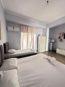 a hotel room with two beds and a window at Almer room 2 in Himare