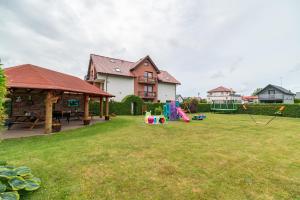 a yard with a house and a playground at Villa Morska, 350 m do plaży in Ustronie Morskie +54 photos