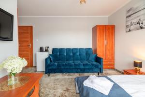 a living room with a blue couch and a table at Villa Morska, 350 m do plaży in Ustronie Morskie