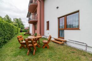 a patio with a table and chairs in the grass at Villa Morska, 350 m do plaży in Ustronie Morskie