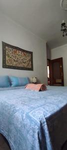 a bedroom with a large bed with a blue blanket at La Tua Pausa Torinese in Turin +2 photos