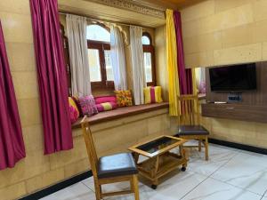 a room with a window seat with chairs and a television at Hotel Zaza Jaisalmer in Jaisalmer
