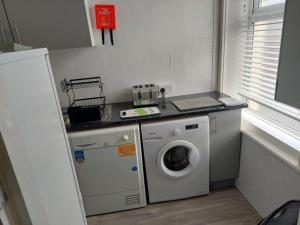 a kitchen with a washing machine and a washer at Edenfield Lodge in Blackpool