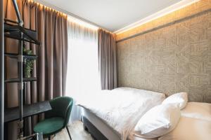 a bedroom with a bed and a green chair at Centrum Hotel in Akureyri
