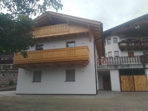 a white building with a balcony on the side at Mitterhofer Appartements in Villandro