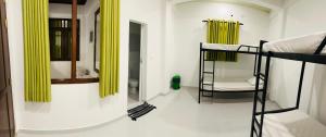 a room with two bunk beds and a mirror at Overnight Beach & Airport Hostel Negombo in Negombo