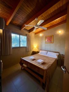 a bedroom with a bed with a ceiling fan at Complejo de Cabañas Aires de Santiago in San Antonio de Arredondo +45 photos