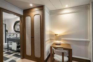 a bathroom with a vanity and a table with a chair at Vincci Soho in Madrid