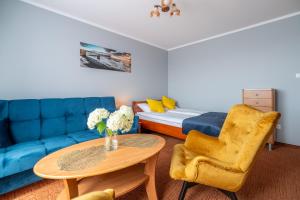 a living room with a couch and a table and a bed at Villa Morska, 350 m do plaży in Ustronie Morskie