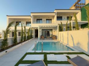 an exterior view of a house with a swimming pool at Bela Villas in Kallithea Halkidikis