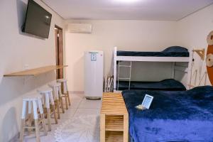 イリャベラにあるChalés da Libélula | Refúgio entre praia e natureza em Ilhabelaの二段ベッド2台とテーブルとスツールのある部屋