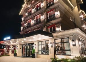 格拉玛多Sofistic Hotel Gramado的一座大型建筑,晚上设有窗户和阳台