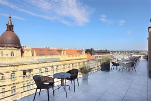 a balcony with tables and chairs on a building at Amarilis in Prague