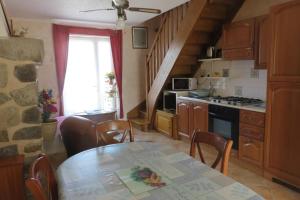 a kitchen with a table with chairs and a stove at Maisons agréables 13ms024 in La Fresnais