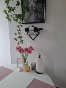 a white table with flowers and a bottle of wine at La Vie en Rose in Verviers
