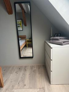 a bedroom with a mirror and a dresser at studio lb 11 Moderne, helle Dachwohnung am Rande der Schwäbischen Alb in Bartholomä
